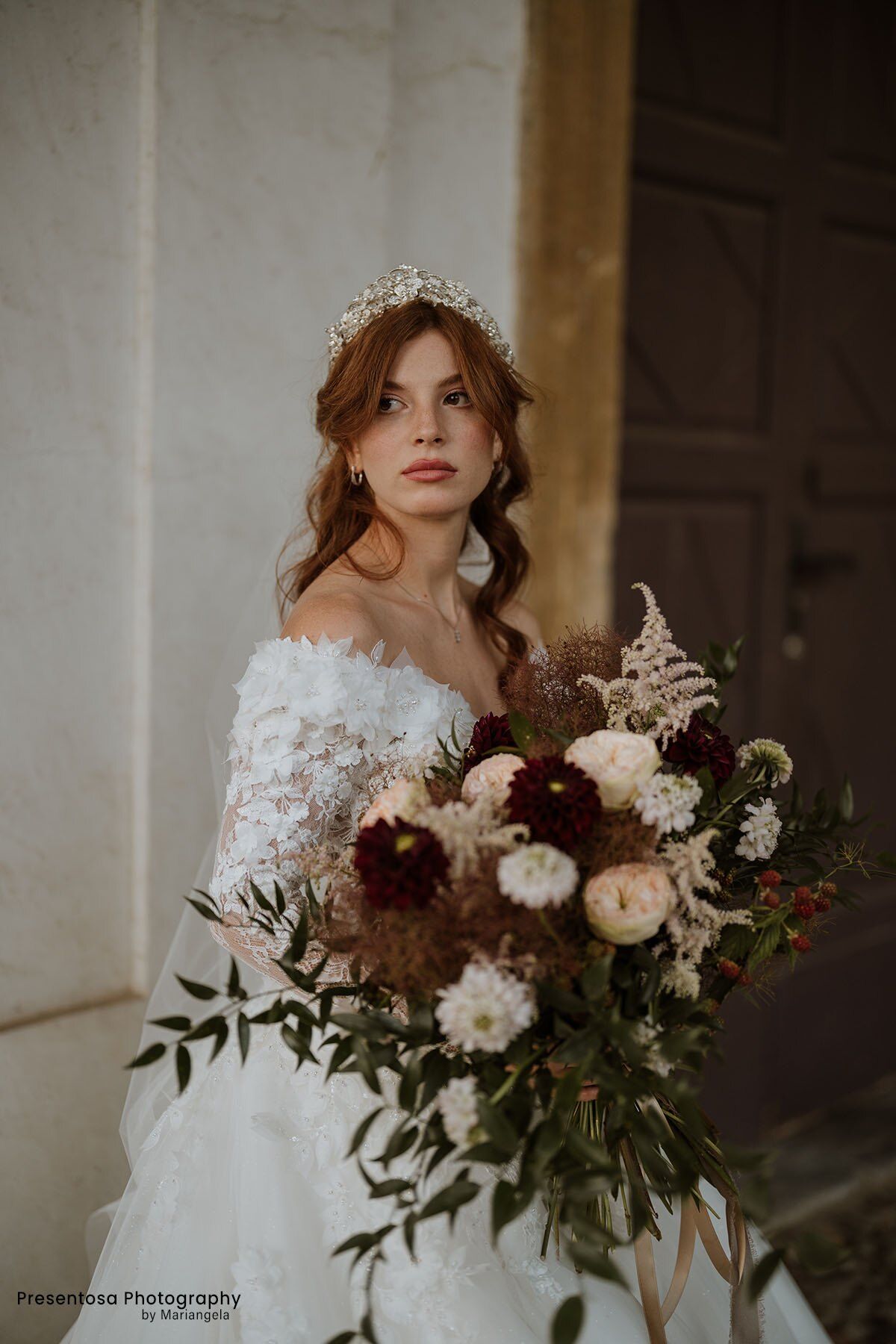 Sposa con un bouquet di dalie bordeaux e rose cipria